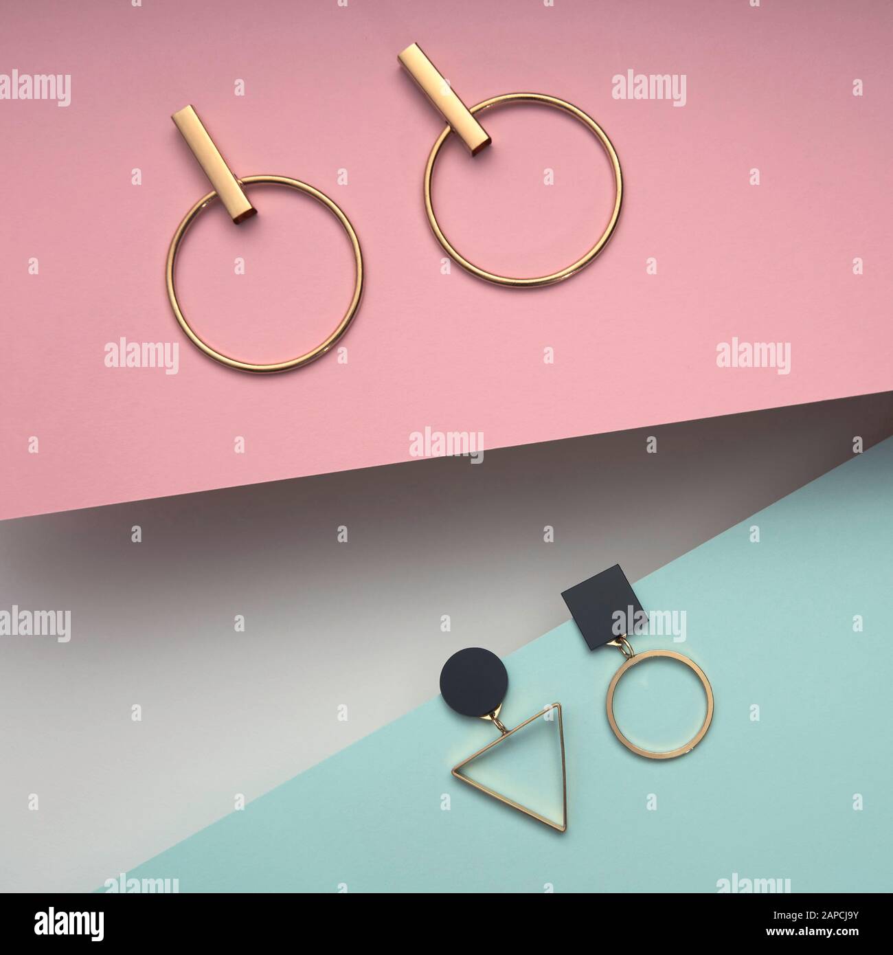 Vista de pendientes de diseño geométrico sobre fondo de papel. Cuadros cuadrados de formas geométricas pendientes papeles rosa y azul Fotografía de stock - Alamy