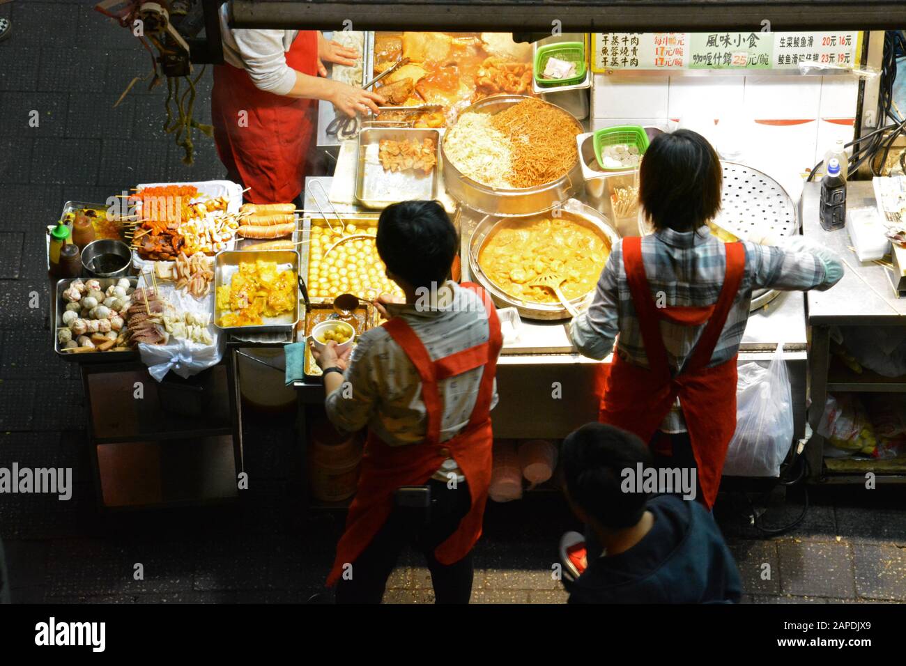 Mirando hacia abajo a un vendedor ambulante vendiendo comida local en el barrio de moda de Wan Chai en Hong Kong. Foto de stock