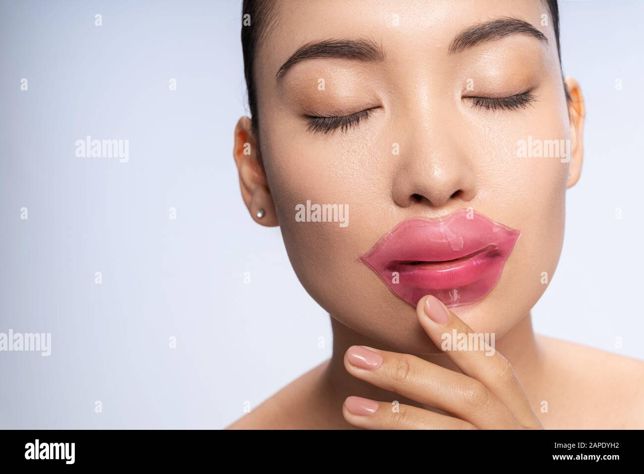 Encantadora señorita con parches en sus labios posando para cámara Foto de stock