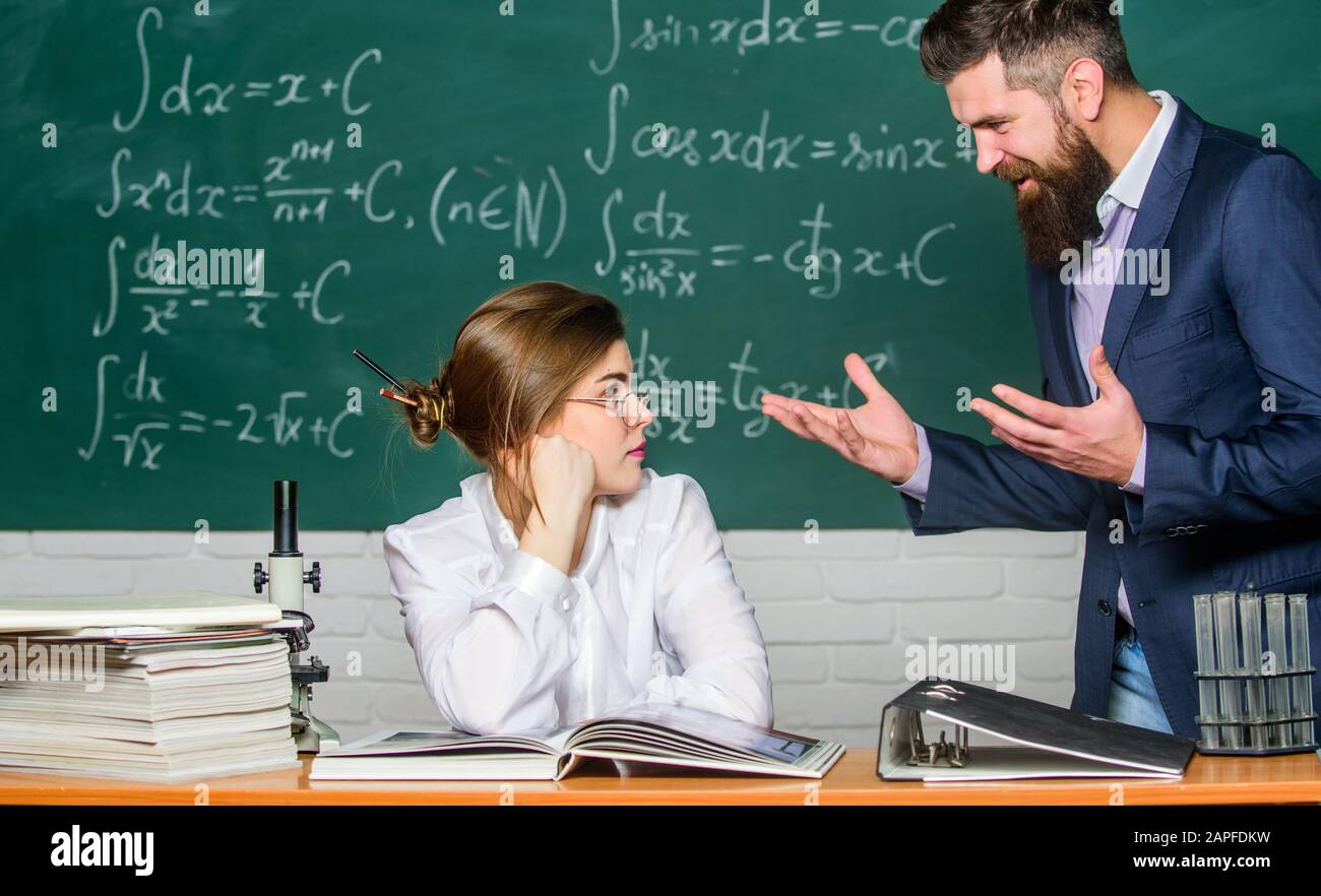 Situación de conflicto. Conflicto escolar. Profesor exigente. Maestro estricto hombre barbudo serio que tiene conflicto con la estudiante niña. El hombre se comunica infeliz. El director de la escuela habla sobre el castigo. Foto de stock