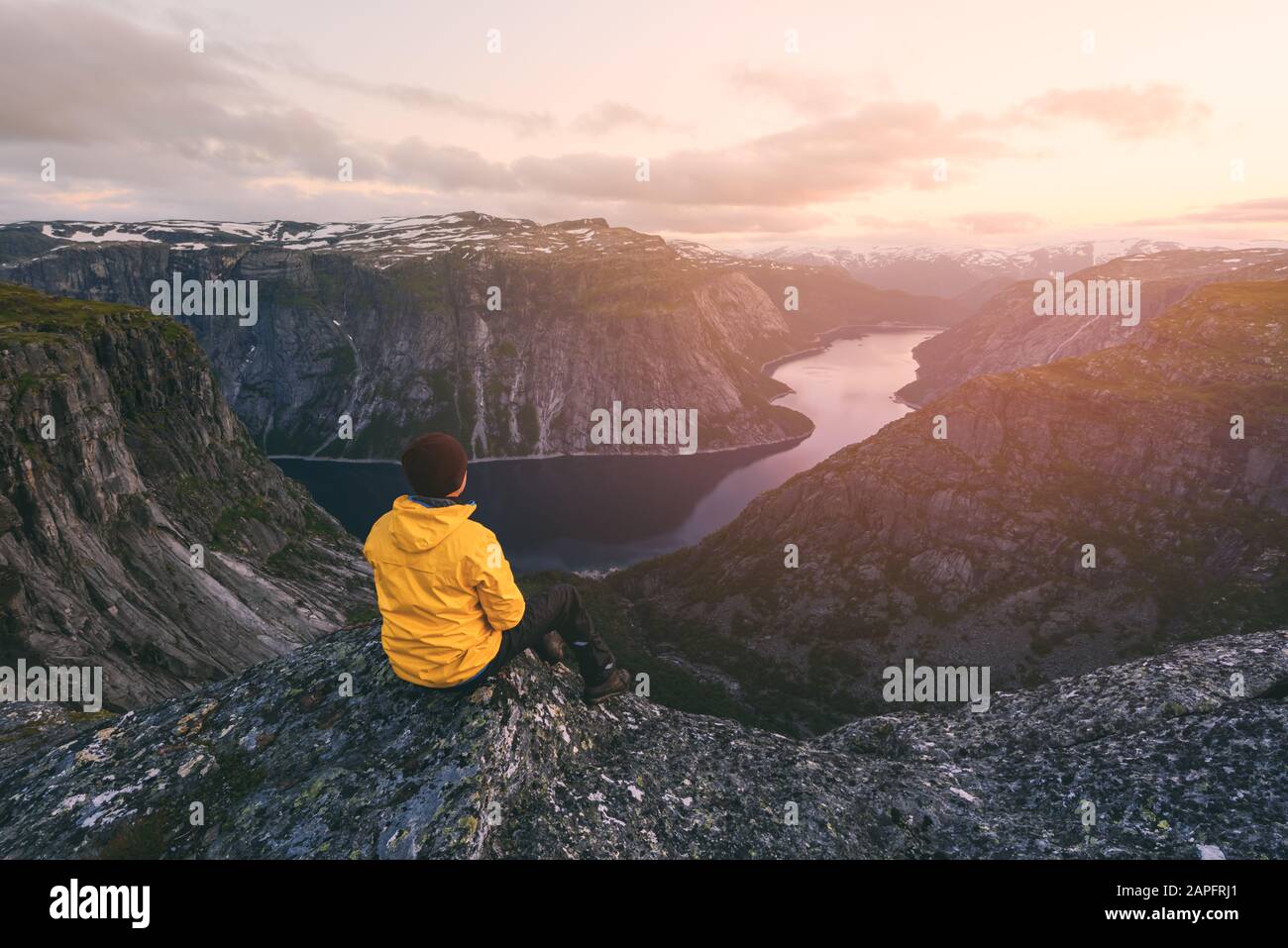 Turista en solitario en la roca Trolltunga - el acantilado escénico más espectacular y famoso de Noruega. Fotografía de paisajes Foto de stock