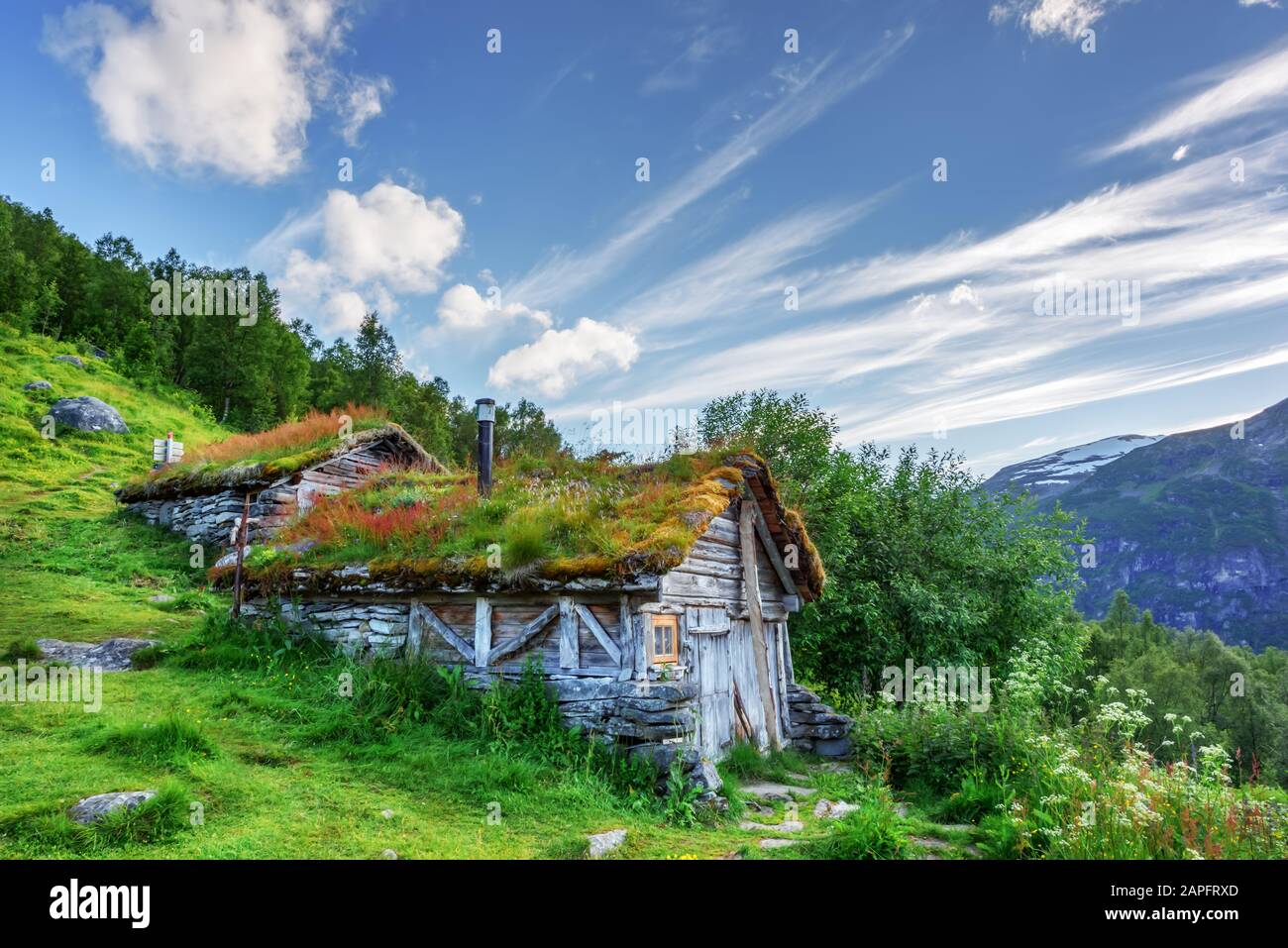 Casas de madera antiguas típicas noruegas con techos de hierba cerca del fiordo Sunnylvsfjorden y las famosas cascadas de Seven Sisters, al oeste de Noruega. Fotografía de paisajes Foto de stock