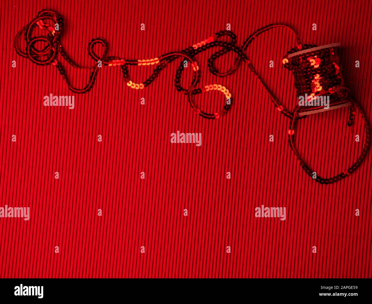 El carrete de lentejuelas rojas sobre un fondo corrugado rojo festivo  Fotografía de stock - Alamy