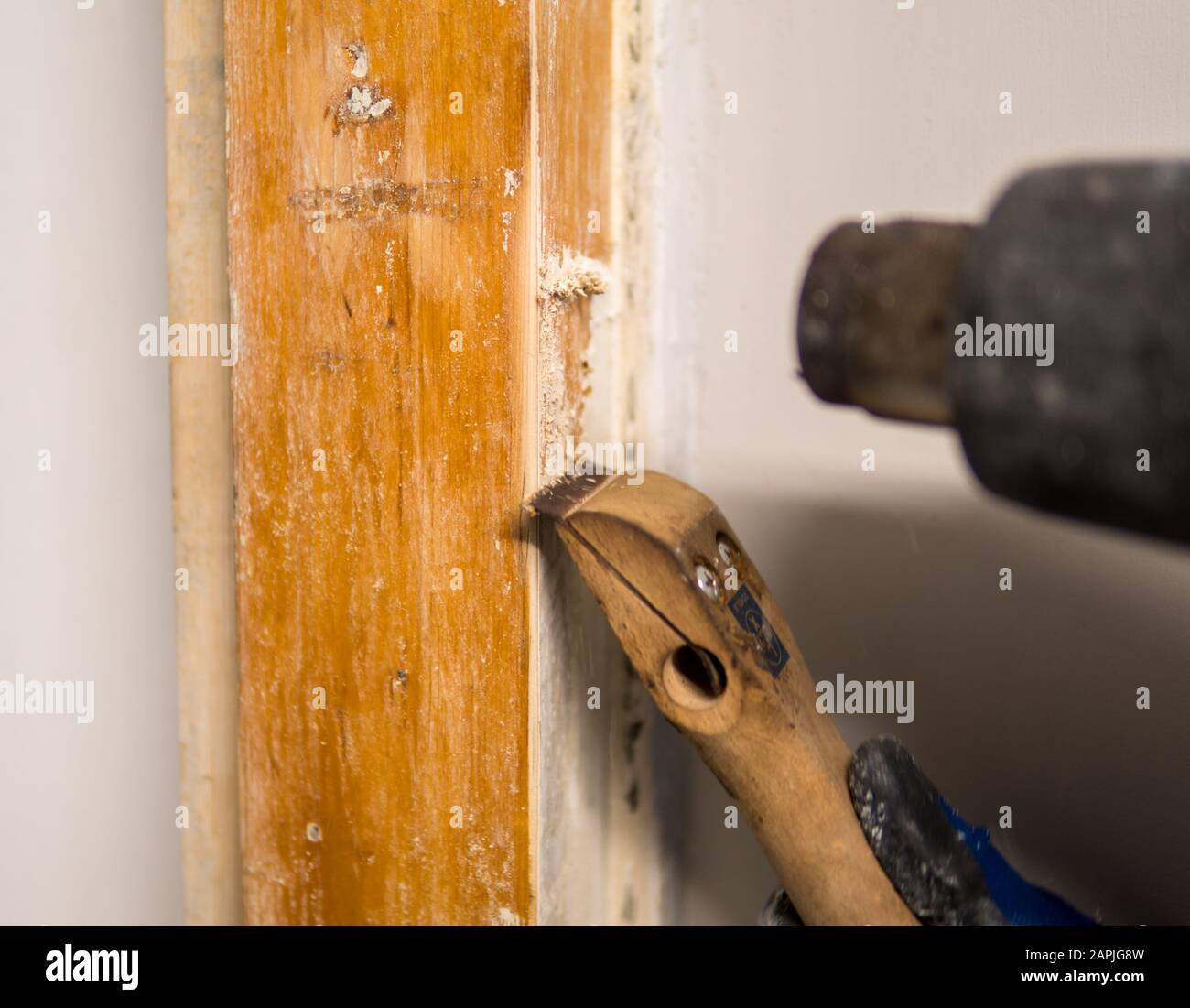 Detalle de quitar pintura blanca vieja del marco de la puerta con pistola  de calor y raspador Fotografía de stock - Alamy