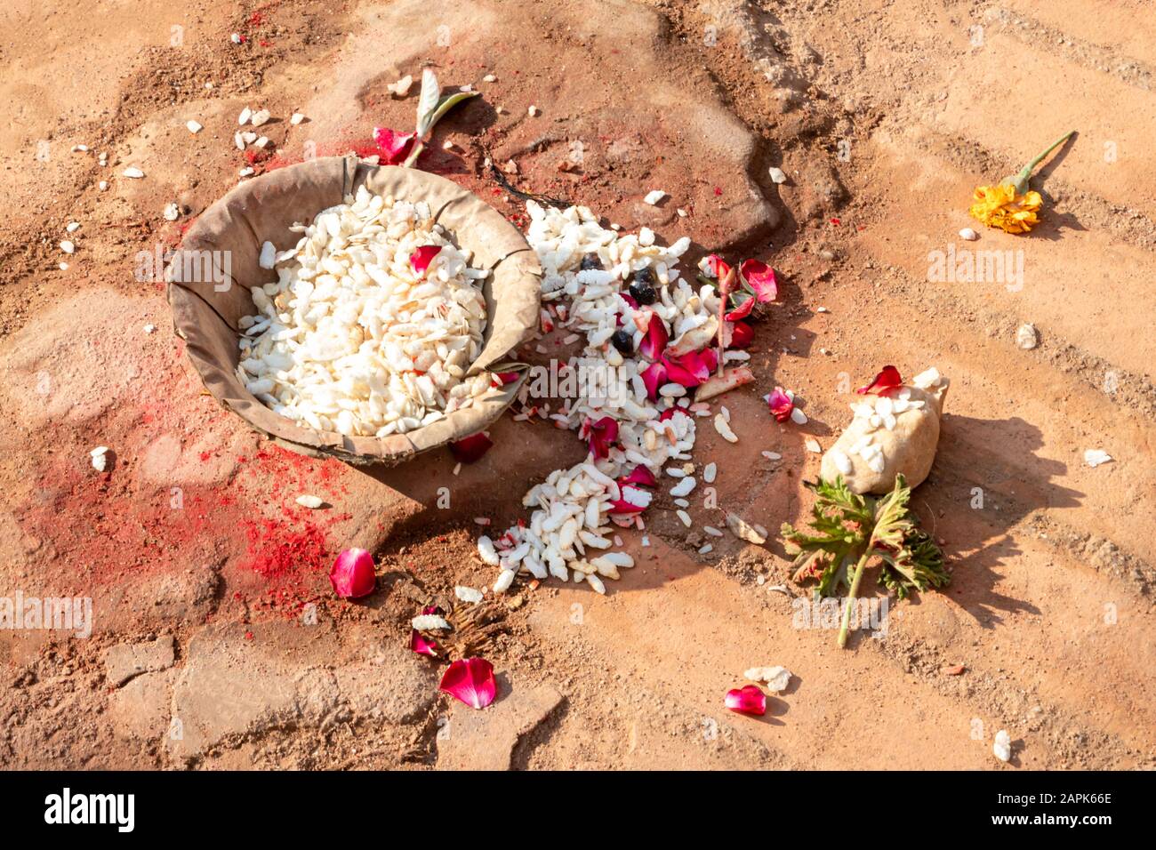 Arroz y ofrenda floral en el piso fuera de una puerta principal en Bhaktapur, Katmandú, Nepal Foto de stock
