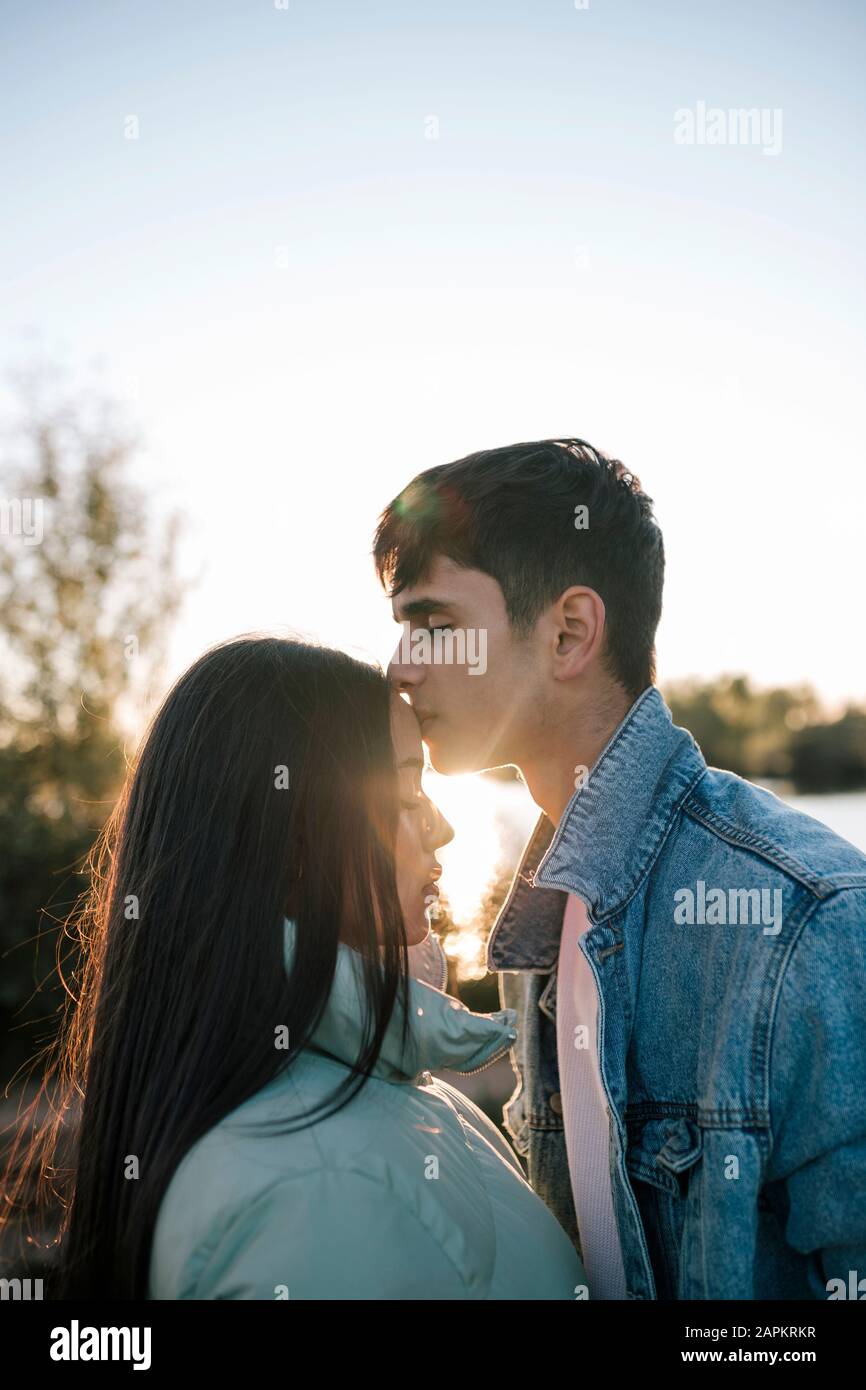 Adolescente besando a su novia en contraluz Foto de stock