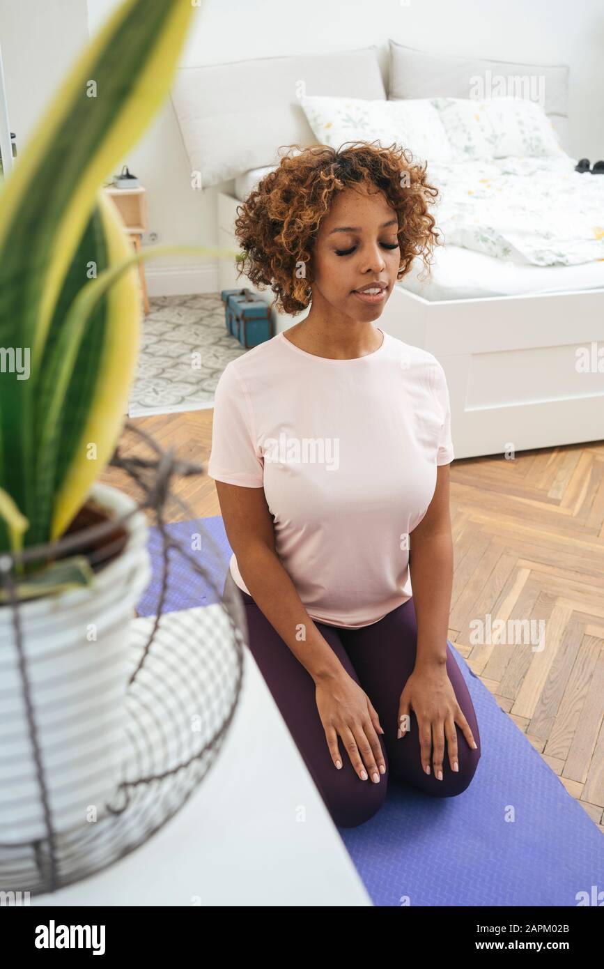 Mujer joven practicando yoga en casa Foto de stock