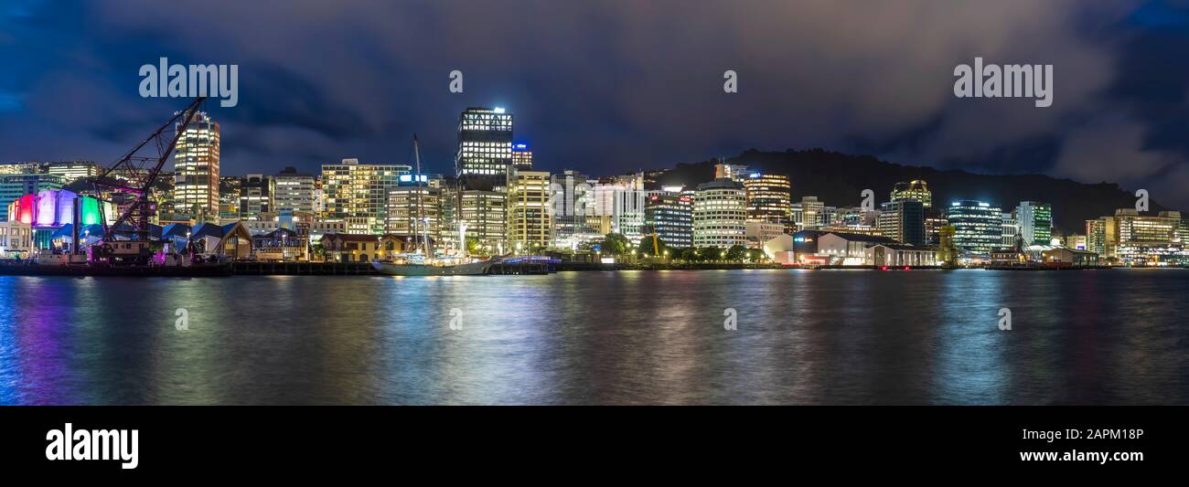 Nueva Zelanda, Wellington, Panorama de la ciudad iluminada frente al mar por la noche Foto de stock