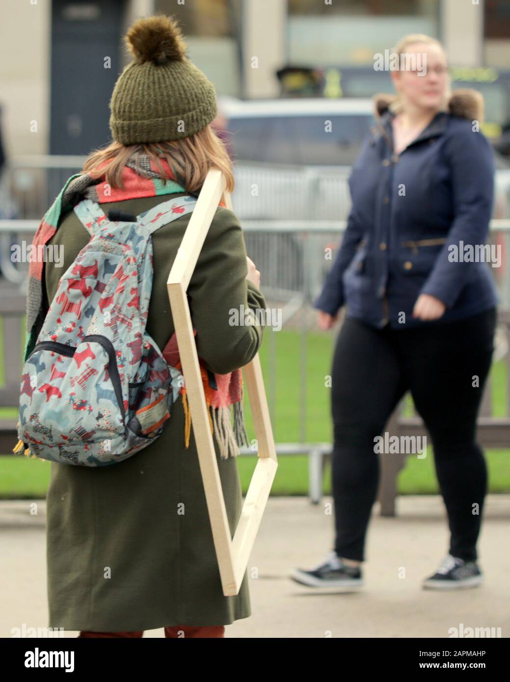 chica caminando en la calle con cuadro vacío marco inusual raro gracioso Foto de stock