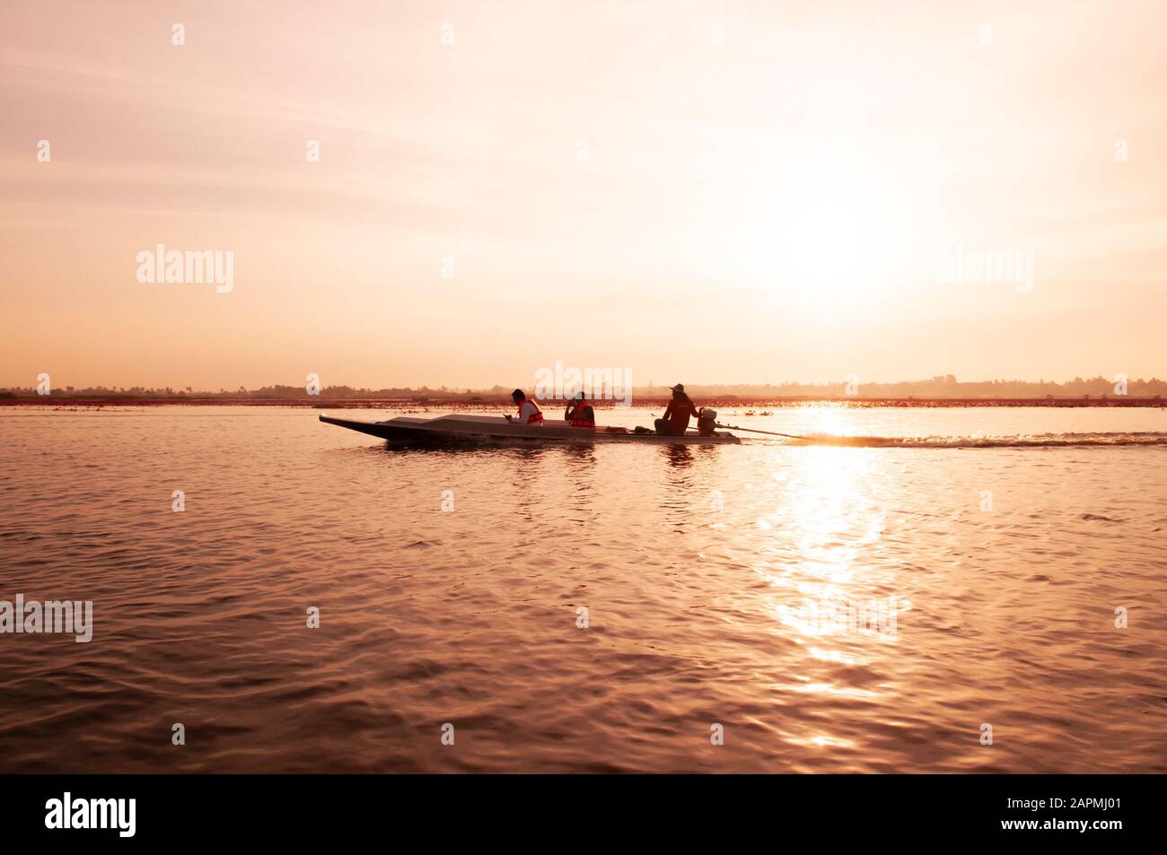 13 de enero de 2019 Udonthani, Tailandia - barco de cola larga tailandés con turista en el tranquilo lago Nong Harn, Udonthani - Tailandia. Barco de madera bajo cálido hermoso Foto de stock