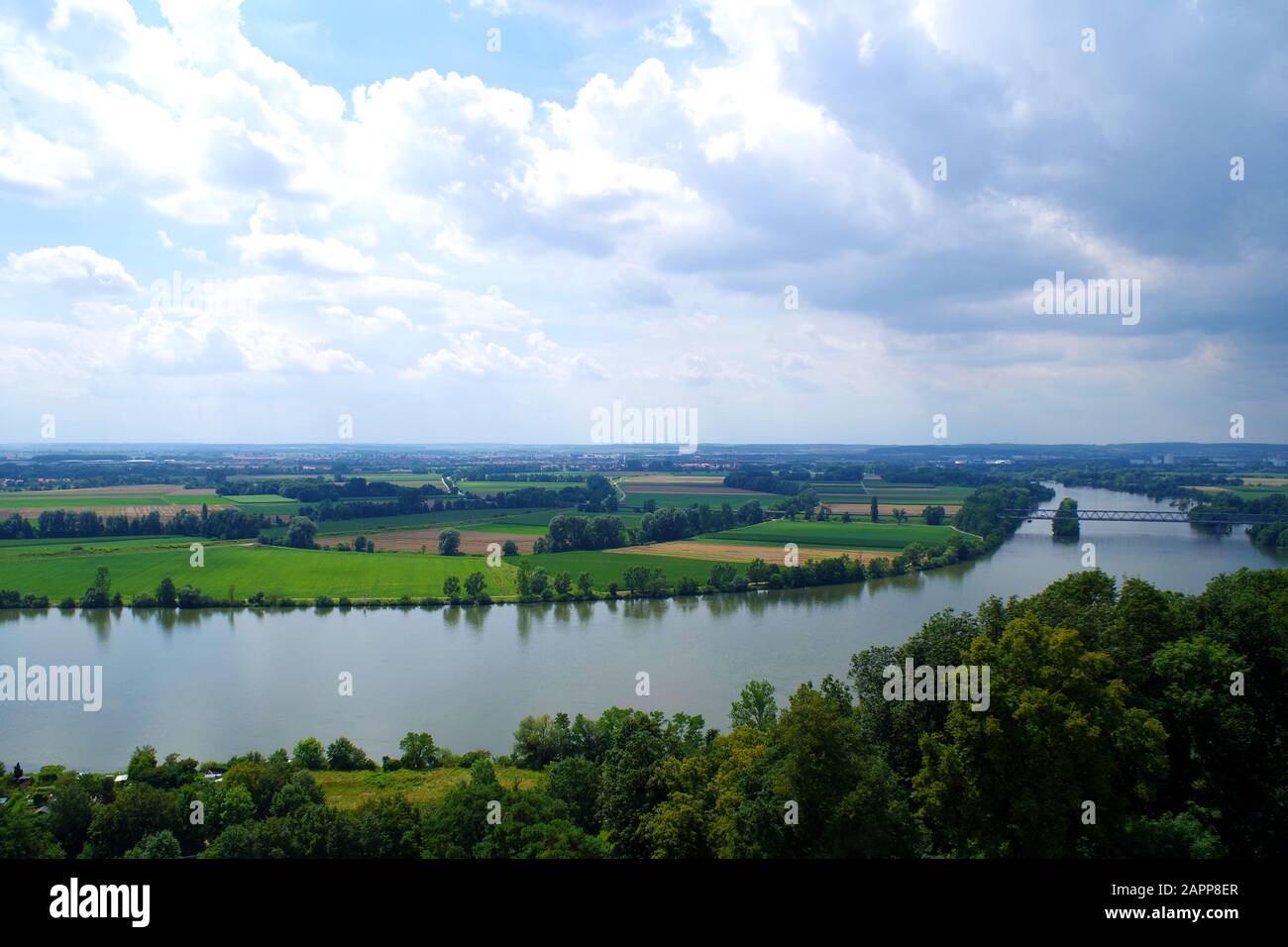 Un paisaje con el río Danubio, visto desde Walhalla (Alemania). Dominan los campos verde y amarillo. bosquecillo grueso de árboles en primer plano. Foto de stock