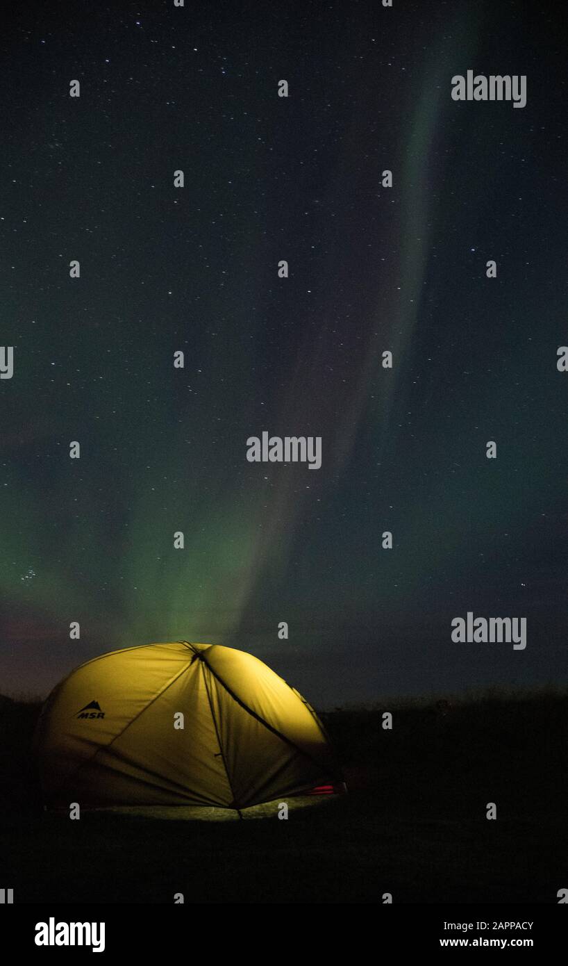 Aurora borealis aurora boreal Islandia con carpa iluminada en primer plano. Disparo Cerca De Strandarkirkja, Selvogur, Islandia Foto de stock