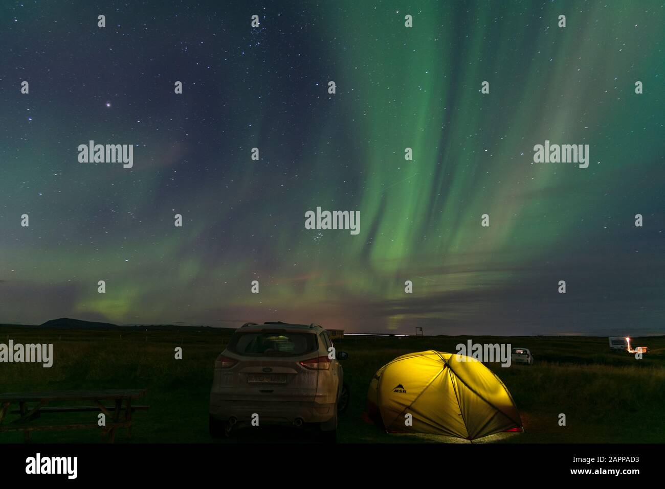 Aurora borealis aurora boreal Islandia con carpa iluminada en primer plano. Disparo Cerca De Strandarkirkja, Selvogur, Islandia Foto de stock
