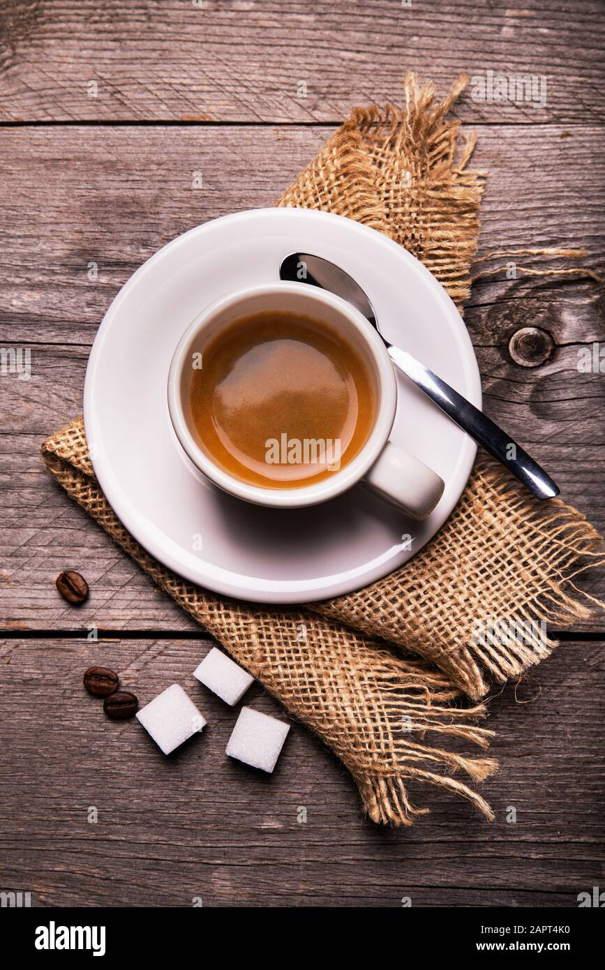 en la mesa rústica de madera, en primer plano, con vistas desde la parte superior, una taza de café espresso cremoso. Composición vertical Foto de stock