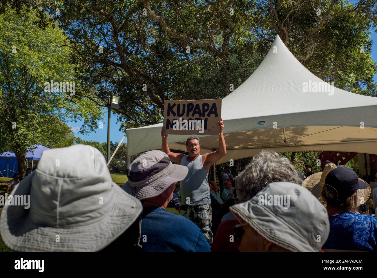 Durante la mañana, el servicio religioso en las celebraciones del día de Waitangi, un hombre maorí mantiene un cartel en el que lee Kupapa Maori (que significa que colabora maorí). Foto de stock
