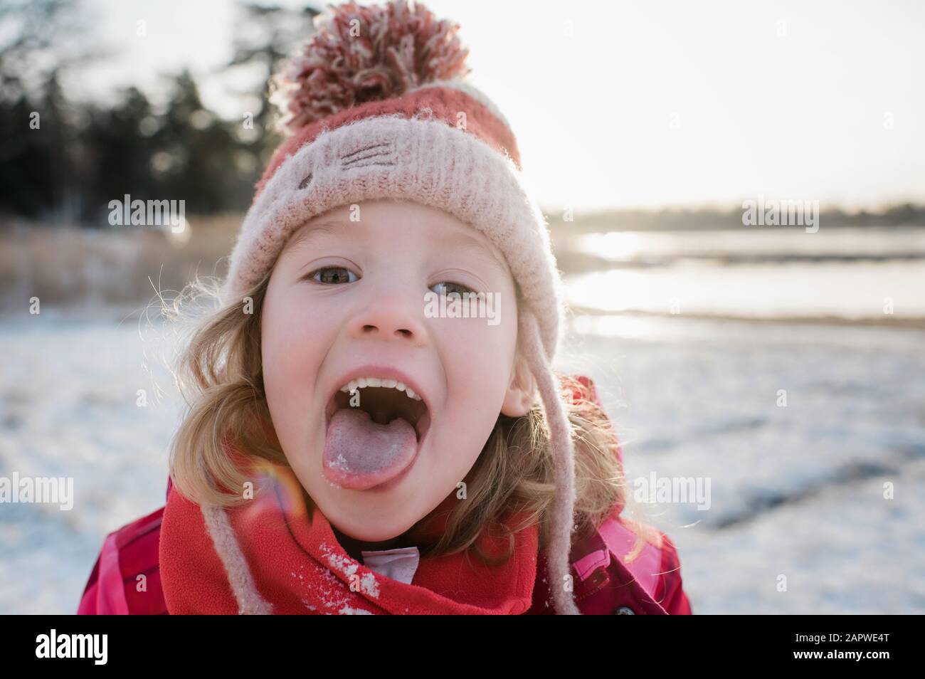 niña atrapando nieve en su lengua fuera en invierno Foto de stock