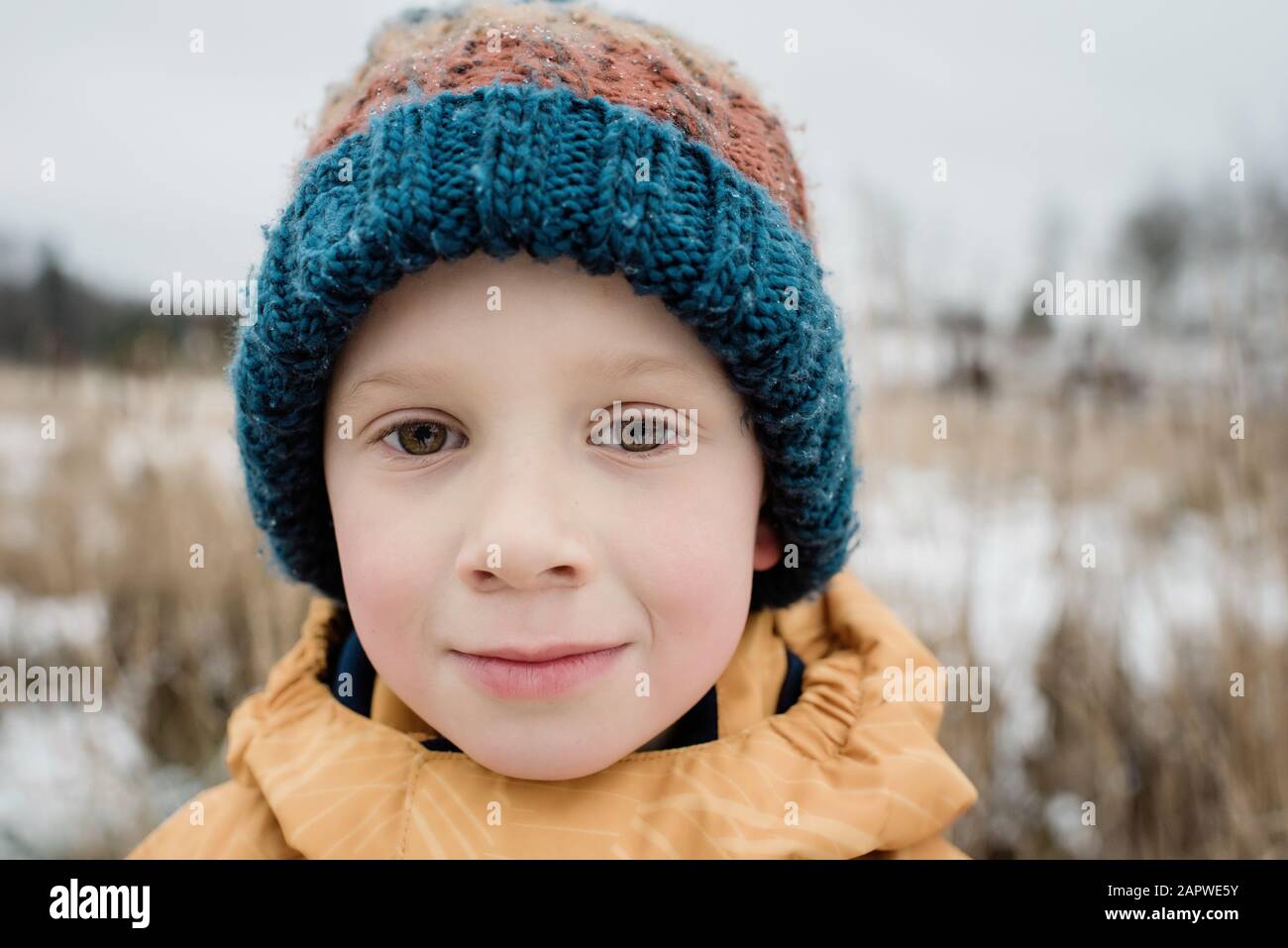 retrato de un niño mirando mientras juega fuera en invierno Foto de stock
