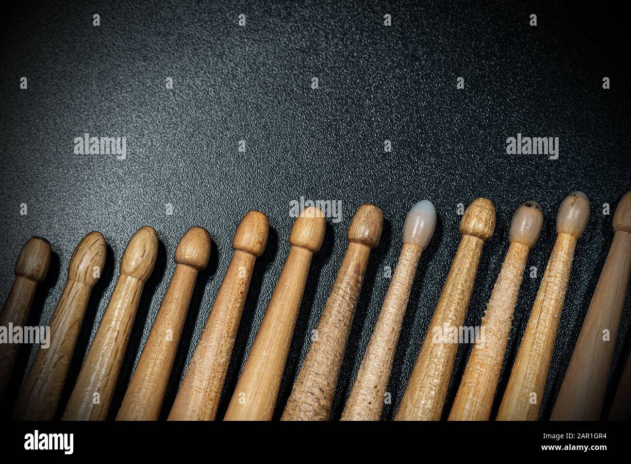 Primer plano de un grupo de muslos de madera usados sobre un fondo oscuro con espacio para copiar. Instrumento de percusión Foto de stock