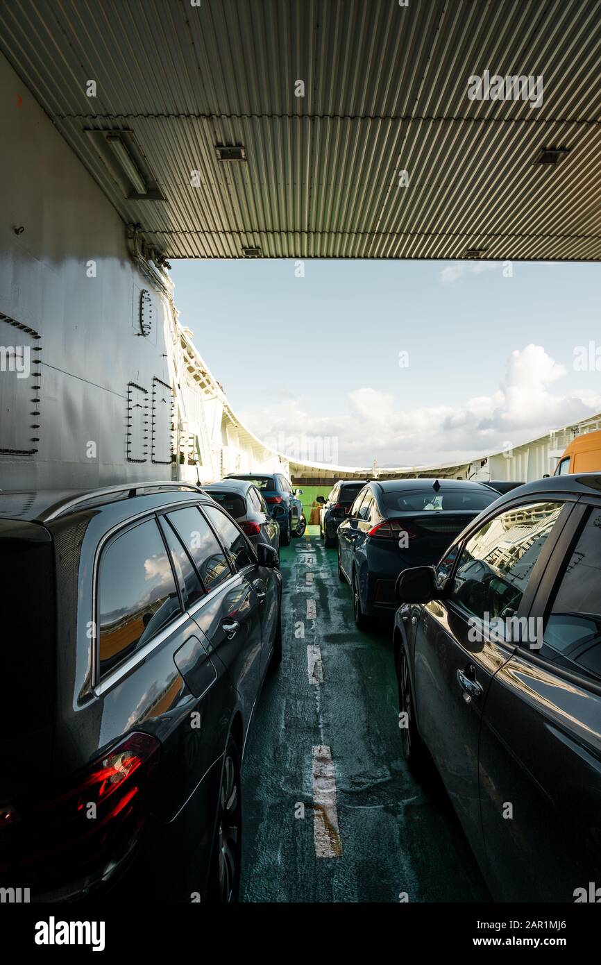 Los coches que se transportan en uno de los transbordadores entre Mortavika y Arsvågen en un día brillante, Noruega Foto de stock