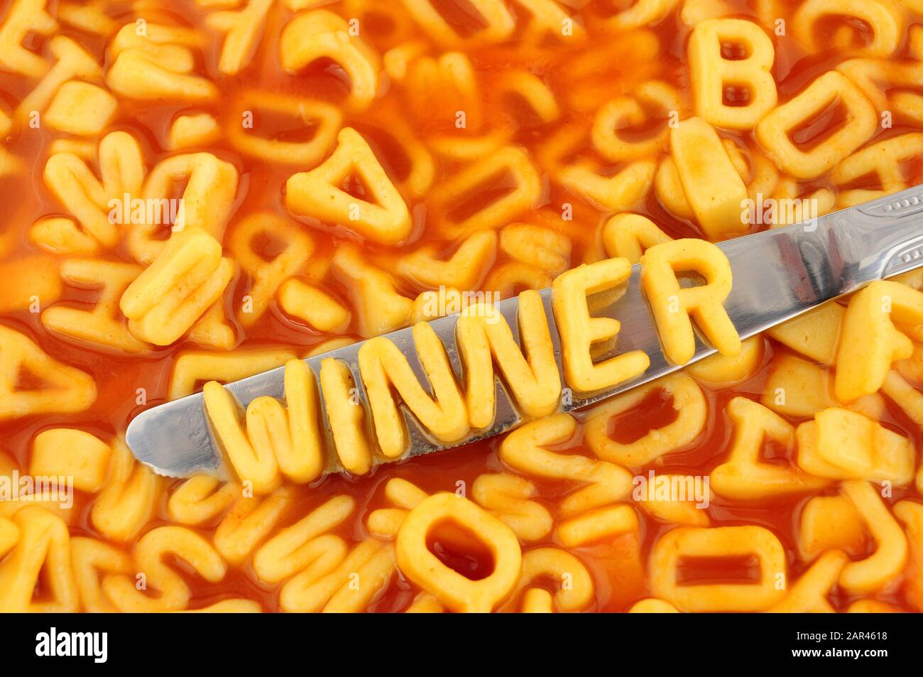 Ganador de espaguetis con letras aleatorias en salsa de tomate de fondo Foto de stock