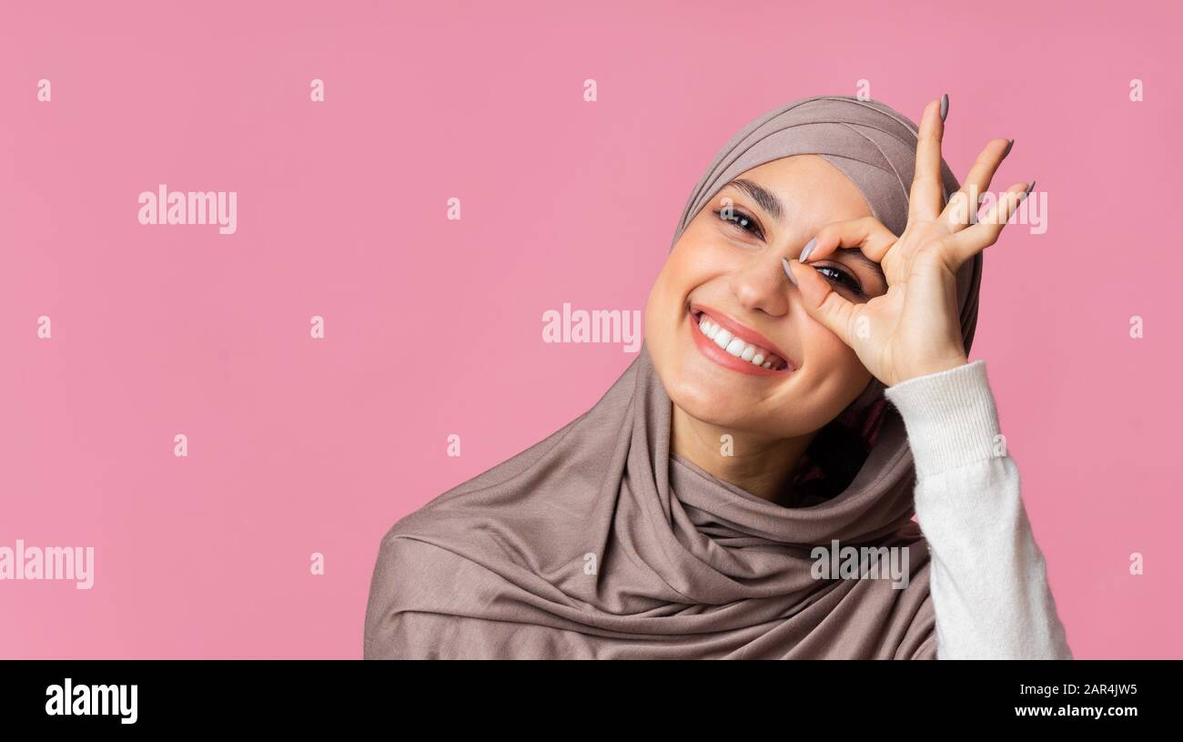 feliz niña árabe en pañuelo mirando a la cámara a través de un gesto normal Foto de stock