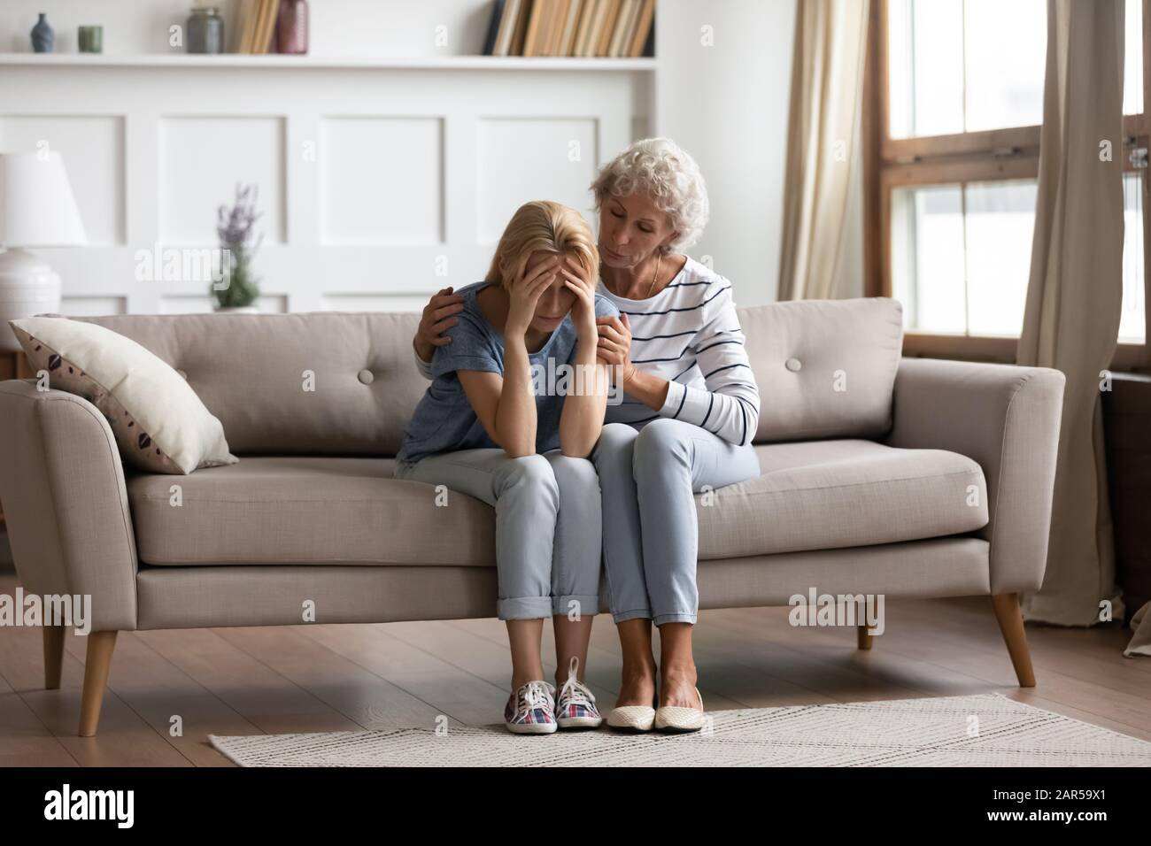 Madre empática de mediana edad que muestra apoyo a la hija mayor. Foto de stock