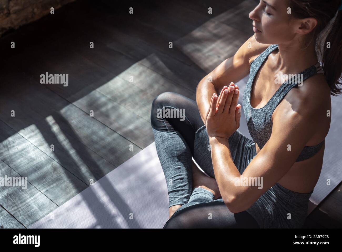 Calma ajuste mujer sana sentarse en la pose del loto hacer yoga medita interior, vista del primer plano Foto de stock