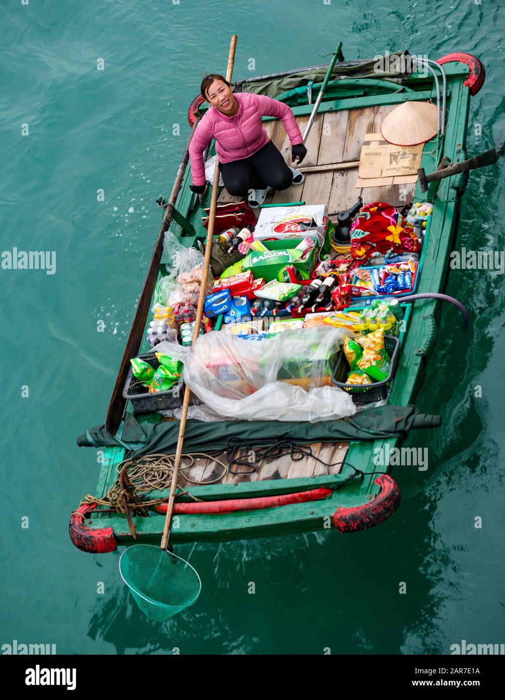 Mujer vietnamita asiática vendiendo bienes de pequeño barco para turistas, Halong Bay, Vietnam, Asia Foto de stock