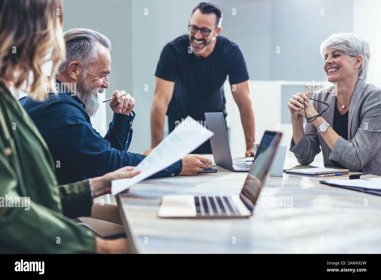 Equipo de profesionales corporativos que se reúnen en un nuevo proyecto. Gente de negocios sonriendo durante una reunión en la sala de conferencias. Foto de stock