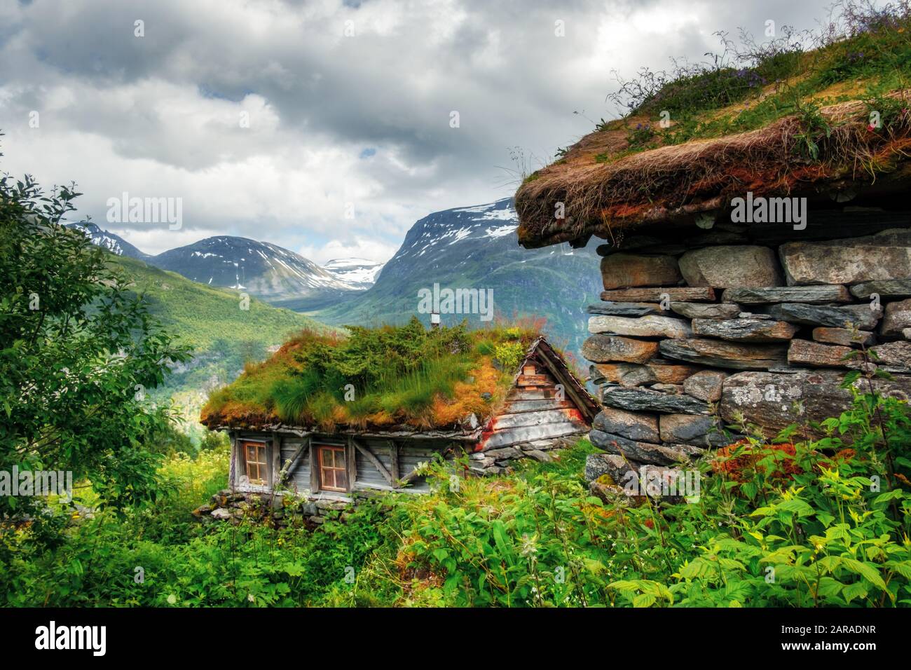 Casas de madera antiguas típicas noruegas con techos de hierba cerca del fiordo Sunnylvsfjorden y las famosas cascadas de Seven Sisters, al oeste de Noruega. Fotografía de paisajes Foto de stock