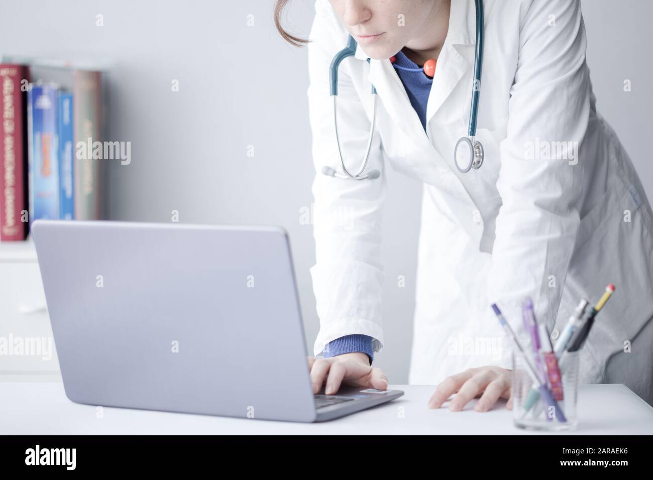 Mujer joven Doctor trabajando con un ordenador portátil en una clínica Foto de stock