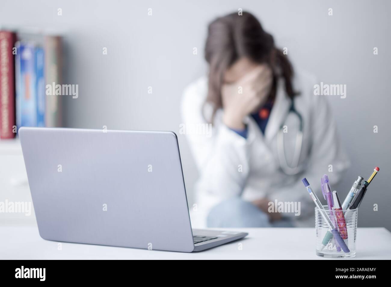Mujer joven cansada Doctor trabajar con un ordenador portátil en una clínica Foto de stock