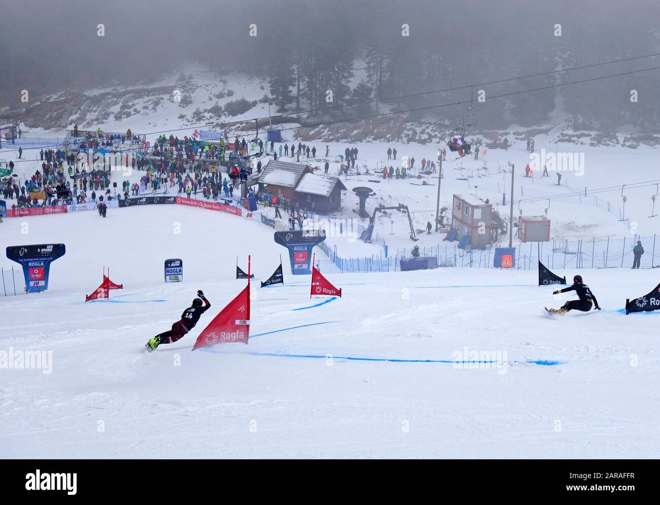 Snowboard competidores paralelos de slalom en la carrera cuesta abajo hacia la línea de meta, COPA DEL MUNDO 2020. Rogla, Eslovenia. Foto de stock