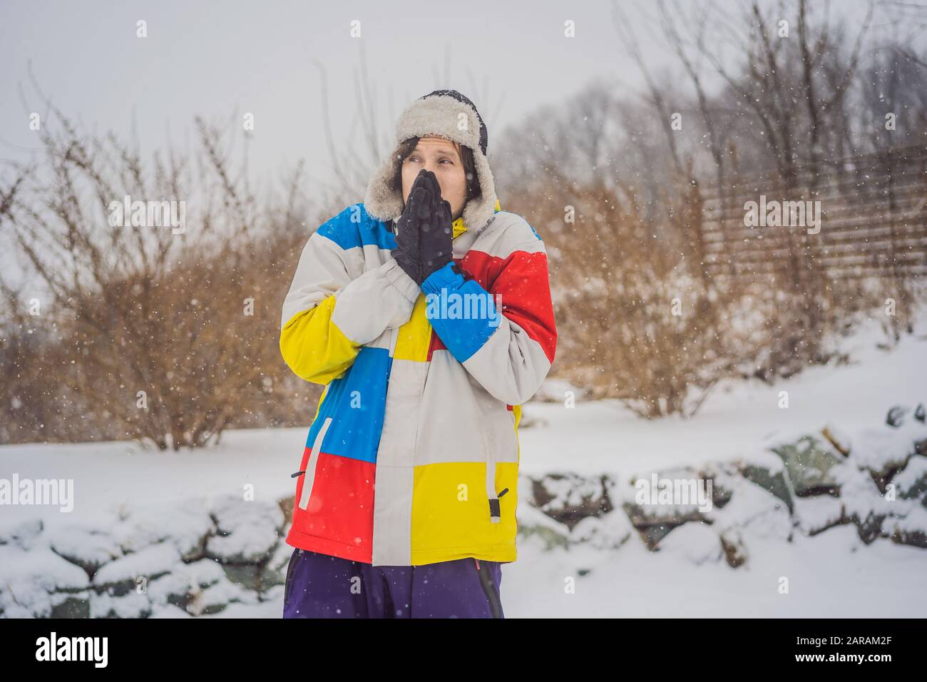 El hombre estaba muy congelado en invierno bajo nevadas. Problemas de invierno Foto de stock