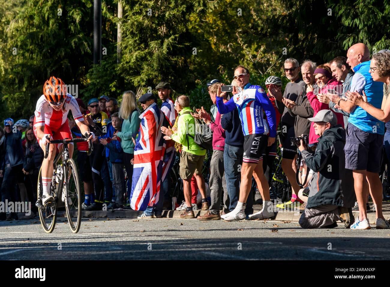 Ciclista de carreras de carretera polaca que monta cuesta arriba, compitiendo en carrera de ciclo, aplaudido y aplaudido por partidarios - Campeonato del Mundo UCI, Harrogate, GB, Reino Unido Foto de stock