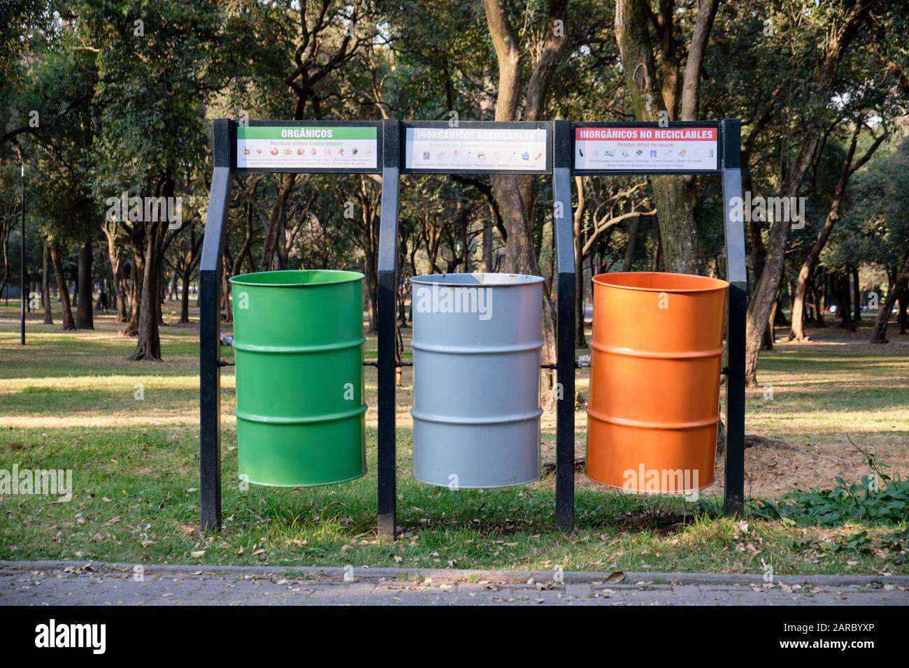 Tres grandes contenedores de residuos para la recogida selectiva de basura en un parque de la ciudad de México, en los colores de la Bandera Nacional. Foto de stock