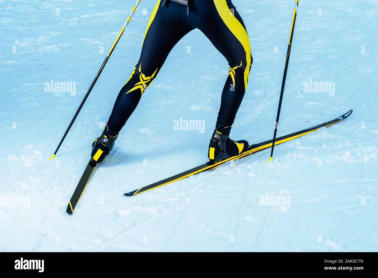 Espalda de biatleta o skier de campo a través con piernas y detalle de equipo de piernas, esquís y bastones Foto de stock
