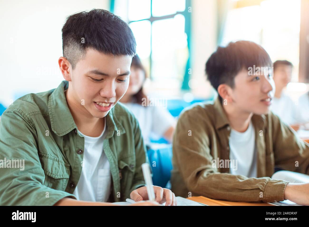 Estudio de estudiantes adolescentes asiáticos con Classmate en el aula Foto de stock