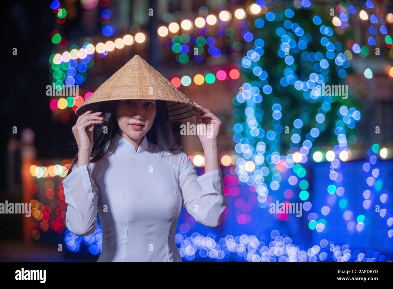 Hermosa mujer con Ao Dai Vietnamita vestido tradicional y turista en la antigua casa de estilo Francia en el festival de Navidad de Sakon Nakhon, Thail Foto de stock