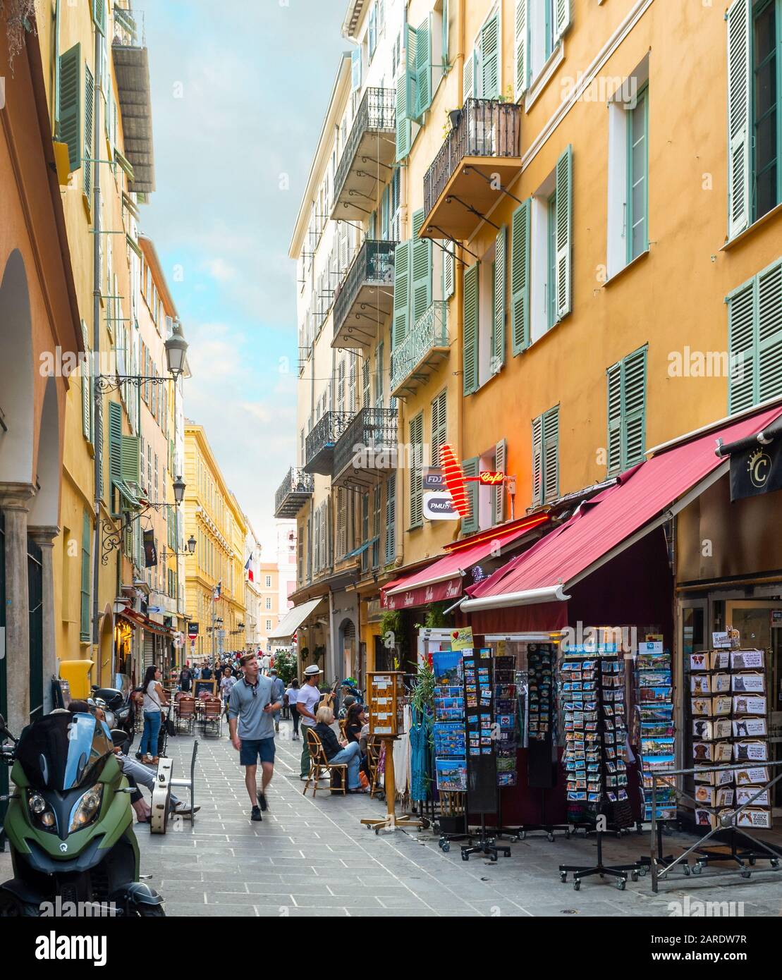 Los turistas compran y cenan en uno de los muchos callejones estrechos y calles en el casco antiguo Vieux Nice zona de la Riviera Francesa. Foto de stock