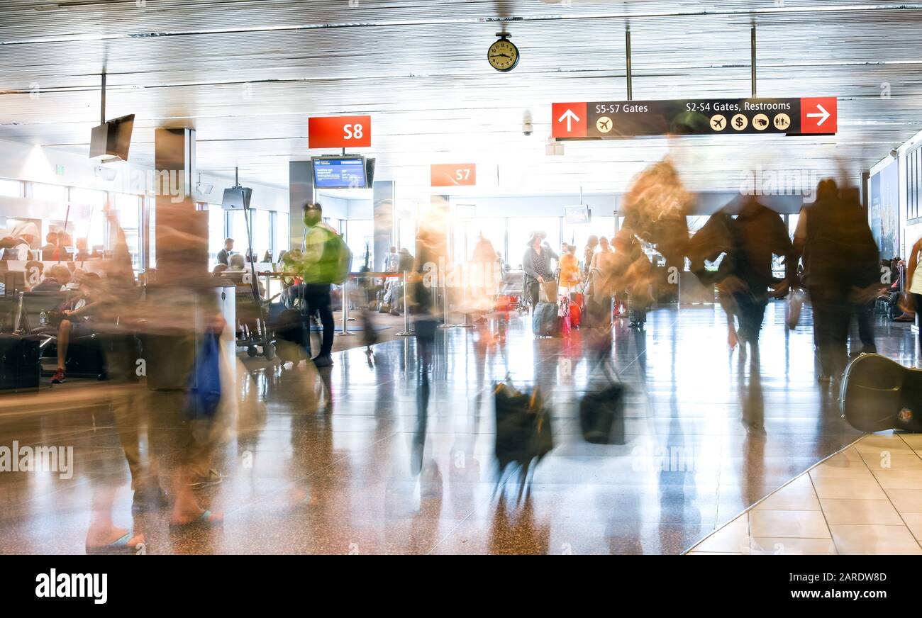 Pasajeros de líneas aéreas en un aeropuerto internacional dentro de una terminal muy concurrida. Foto de stock