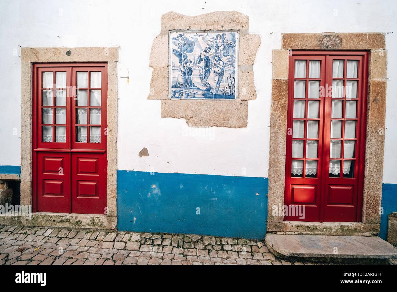 Puertas de color rojo tradicional con paredes blancas y toques azules en  Obidos Portugal Fotografía de stock - Alamy