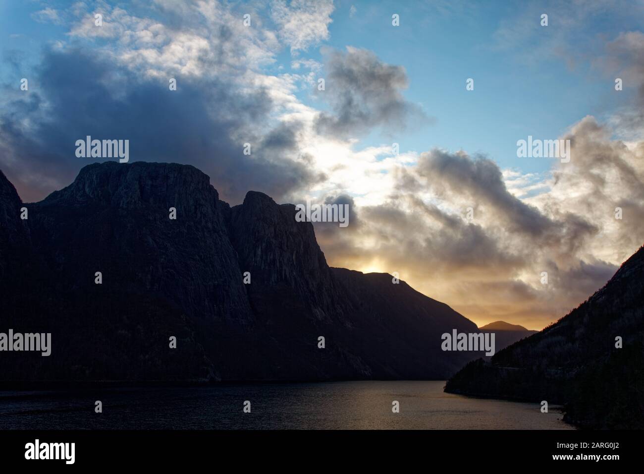 Una puesta de sol un poco nublado sobre el lago - paisaje parecido a un fiordo Foto de stock