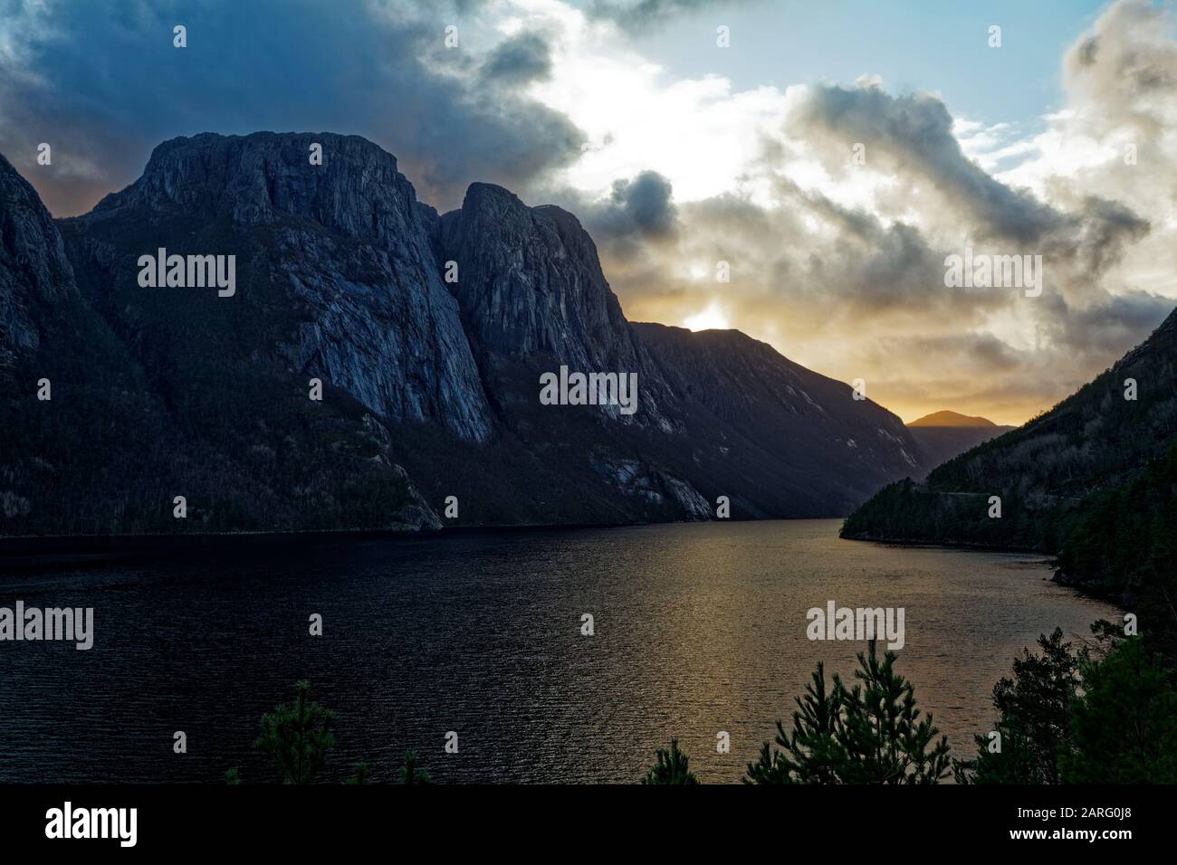 Una puesta de sol un poco nublado sobre el lago - paisaje parecido a un fiordo Foto de stock