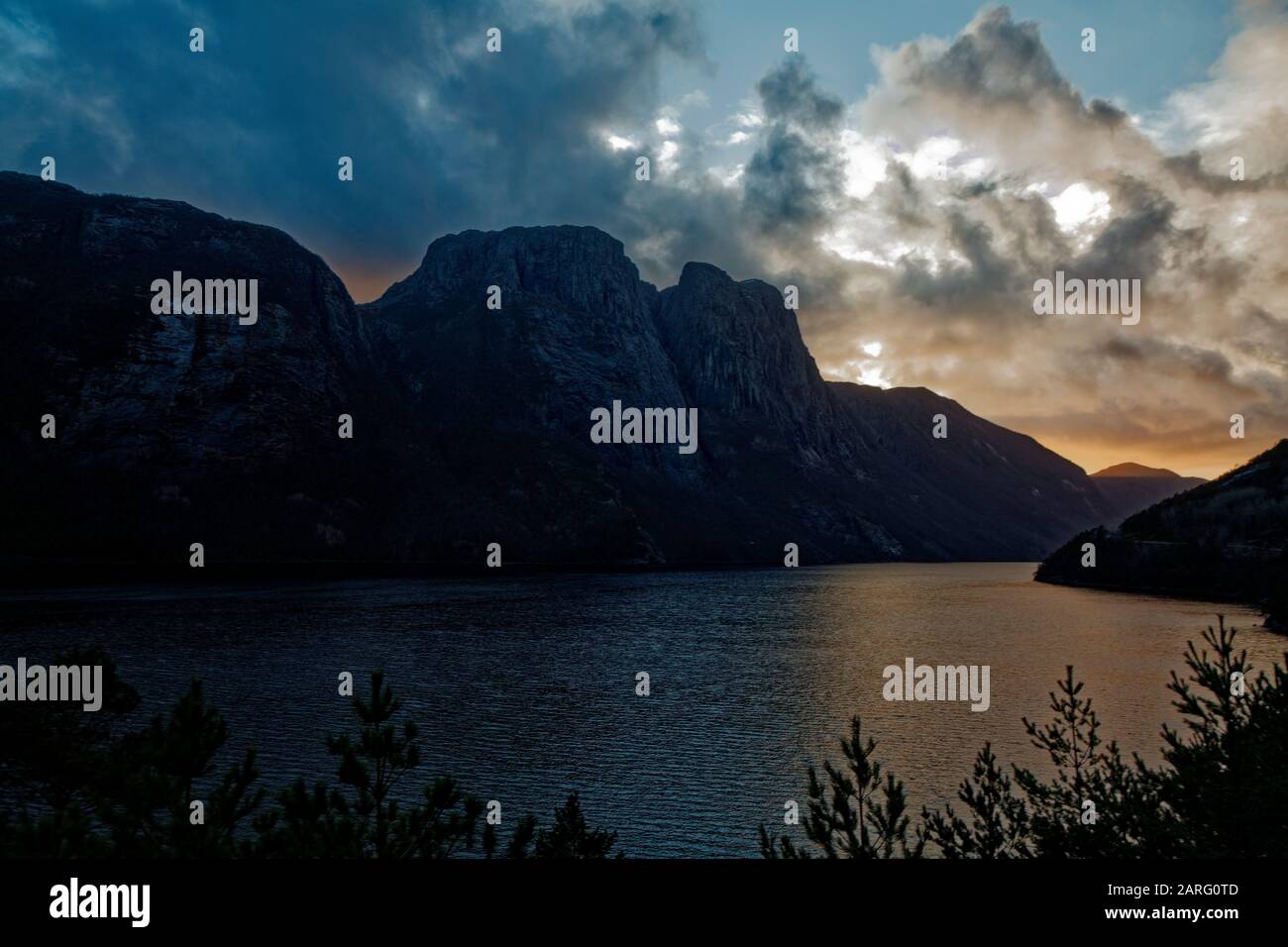 Una puesta de sol un poco nublado sobre el lago - paisaje parecido a un fiordo Foto de stock