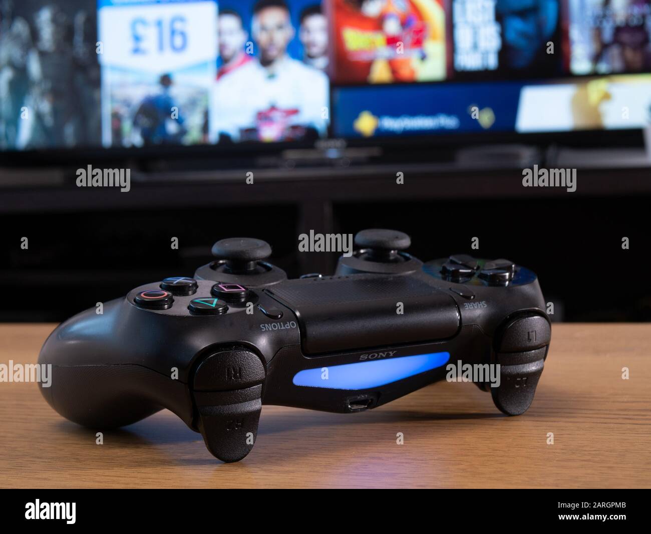 Reino Unido, enero de 2020: Mando a distancia inalámbrico dualshock de Sony  para Playstation 4 delante de la tienda online en la pantalla del televisor  Fotografía de stock - Alamy