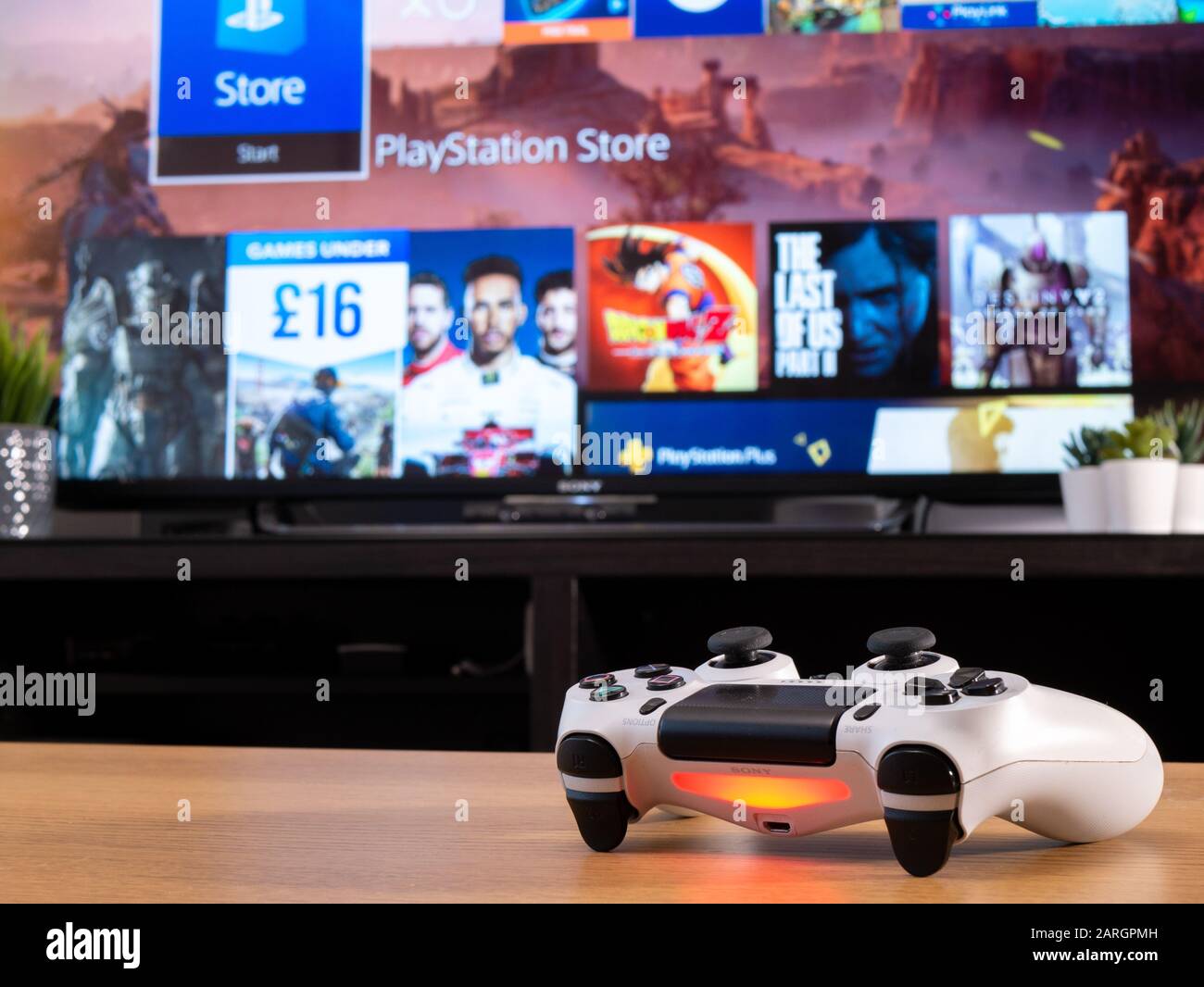 Reino Unido, enero de 2020: Mando Dualshock 4 de Sony blanco para PS4 con tienda  online en la pantalla de televisión detrás Fotografía de stock - Alamy