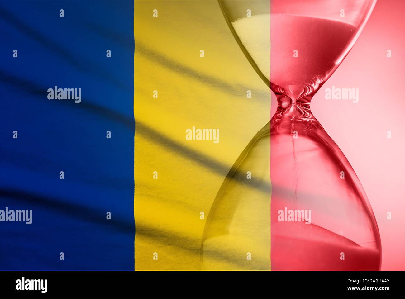 Reloj de arena sobre la bandera de Rumania Foto de stock