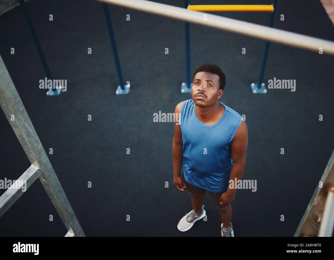 Vista en ángulo alto de un joven deportivo que se prepara para hacer jale encima en un bar en el gimnasio al aire libre en el parque - copyspace Foto de stock