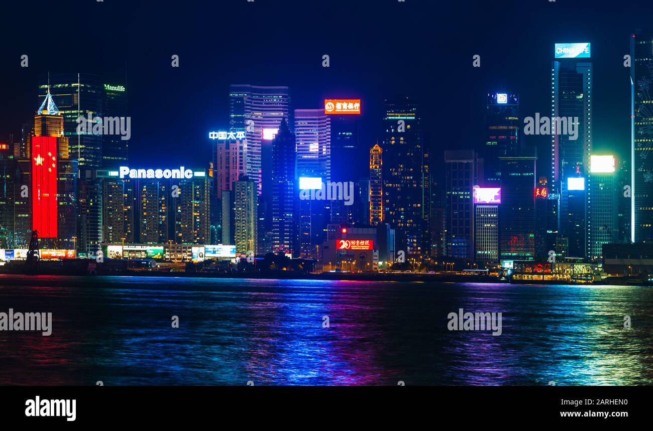 Hong Kong - 20 de julio de 2017: Distrito central de Hong Kong por la noche, rascacielos iluminados en la costa, moderno paisaje urbano asiático Foto de stock